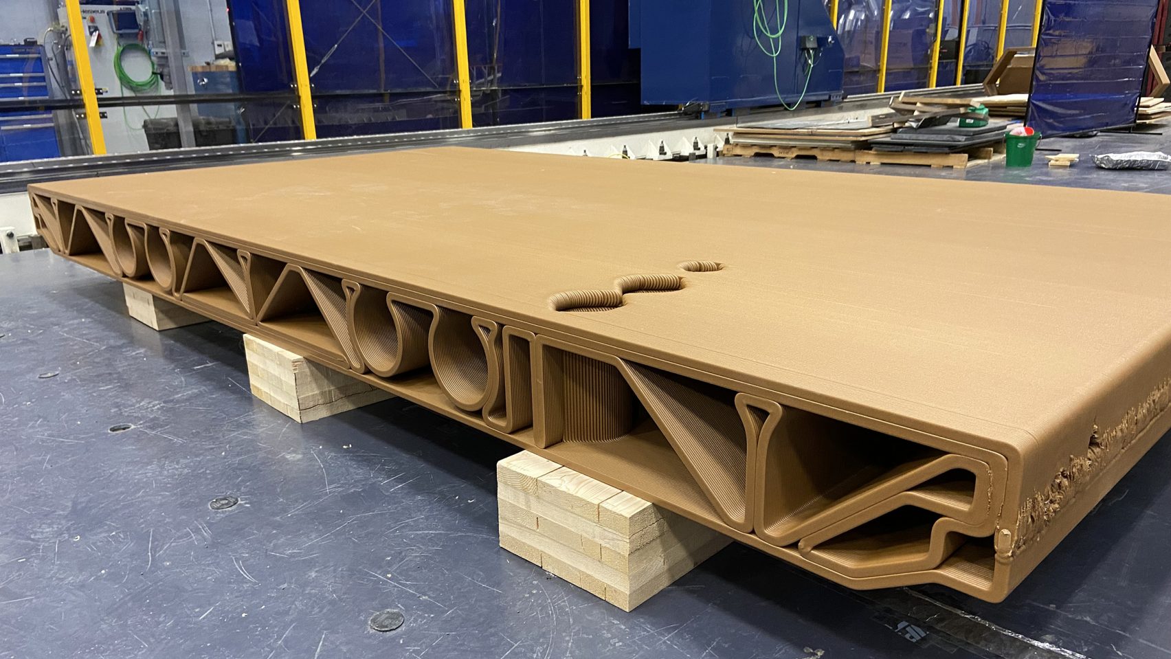 Wood waste and bioplastic floor panel boasts the strength of steel